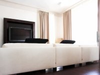 Dining room interior with white sofa, tv